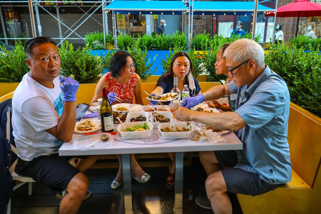 A group dines at an outdoor dining table